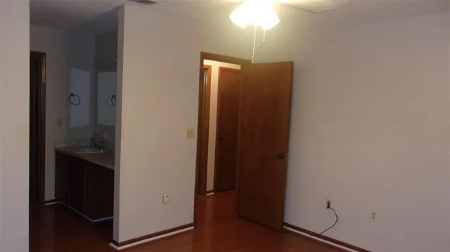 an empty room with wooden floor sink and closet