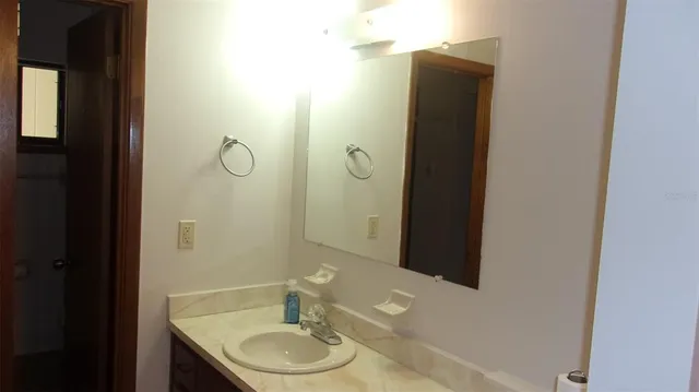 a bathroom with a granite countertop sink and a mirror
