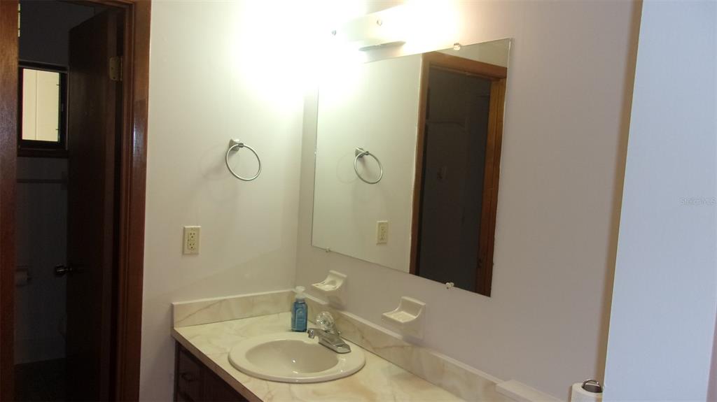 10015 Southwest 90th Court Ocala, FL 34481 - Photo 22 of 48 a bathroom with a granite countertop sink and a mirror