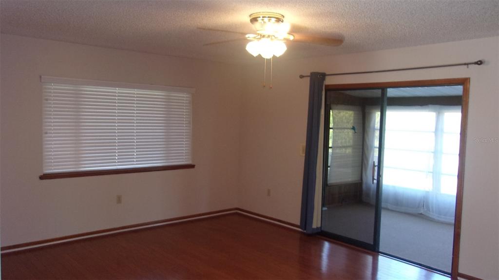10015 Southwest 90th Court Ocala, FL 34481 - Photo 3 of 48 a view of empty room with wooden floor and fan