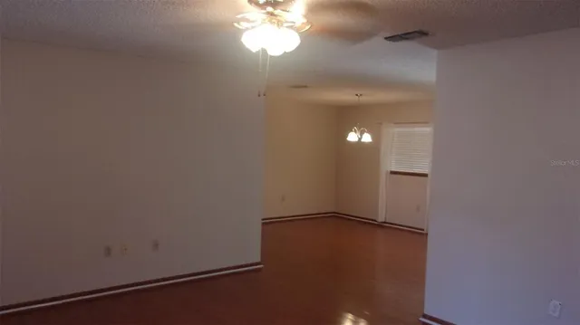 an empty room with a fan & a window