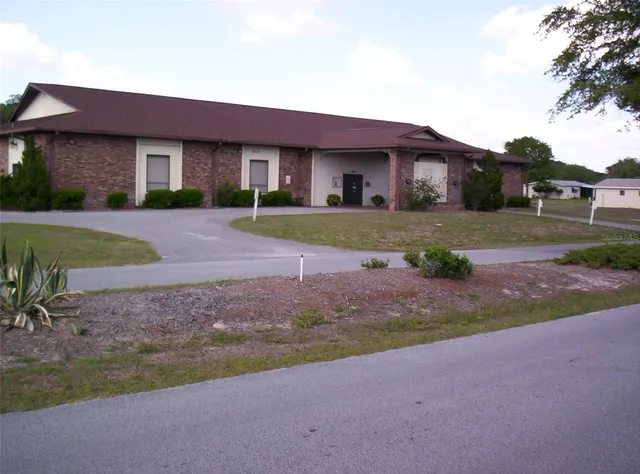 a front view of house with yard and trees around