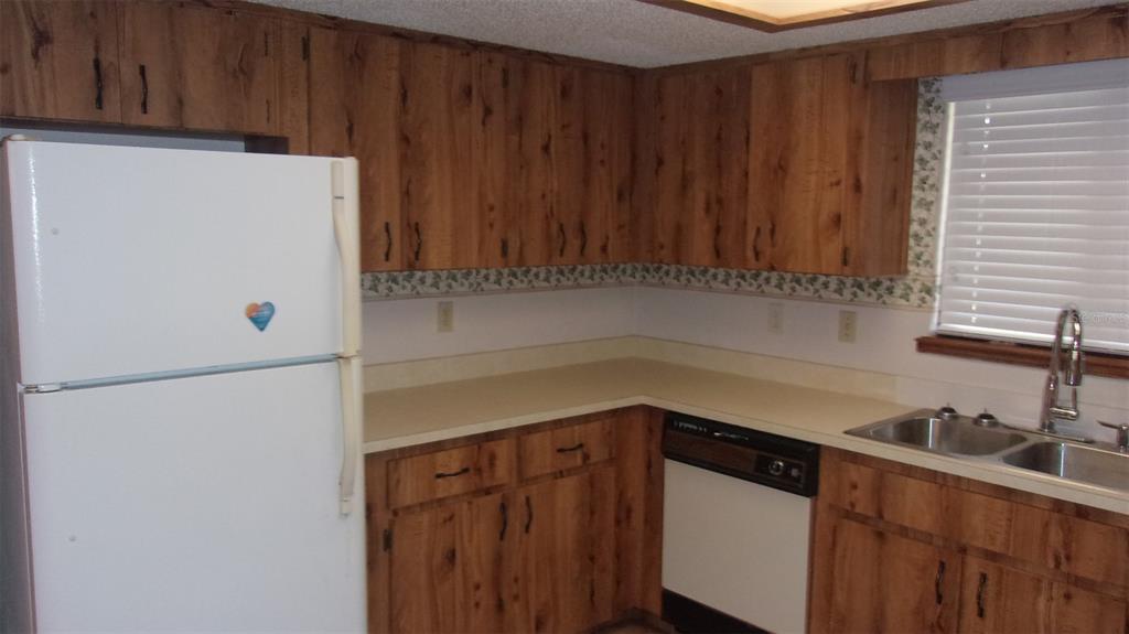 10015 Southwest 90th Court Ocala, FL 34481 - Photo 8 of 48 a white refrigerator freezer sitting inside of a kitchen