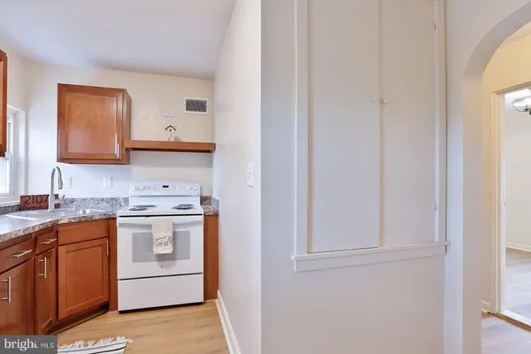 a kitchen with stainless steel appliances granite countertop a sink and a stove with wooden floor