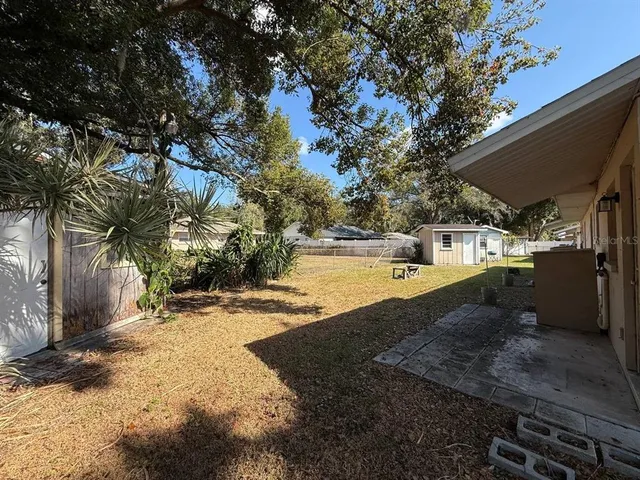 a view of a yard with wooden fence
