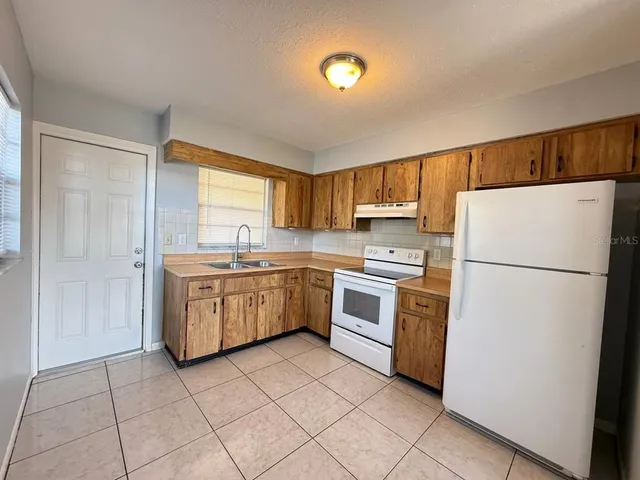 a kitchen with a white stove top oven and refrigerator