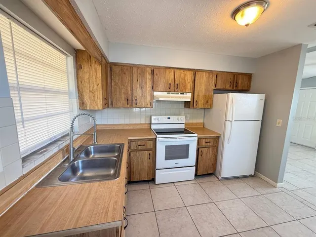 a kitchen with a refrigerator sink and stove