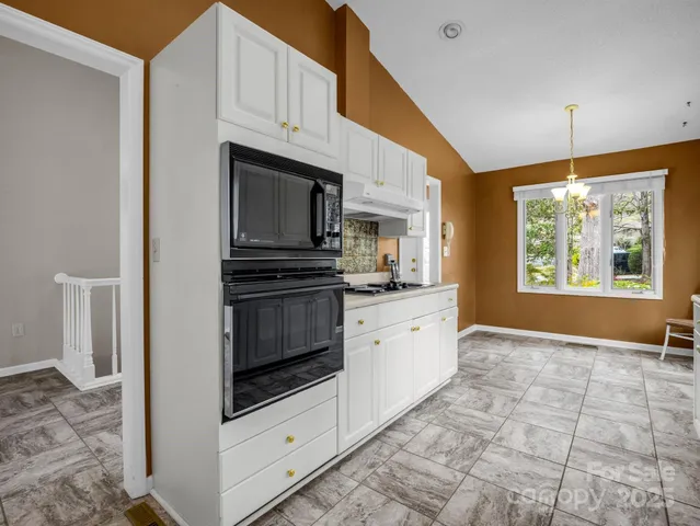a kitchen with stainless steel appliances kitchen island granite countertop a stove a sink and a microwave