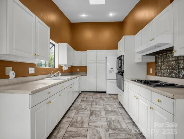 a large kitchen with stainless steel appliances kitchen island granite countertop a sink and cabinets