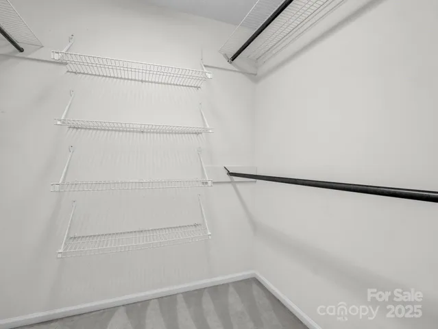 a view of walk in closet with empty racks