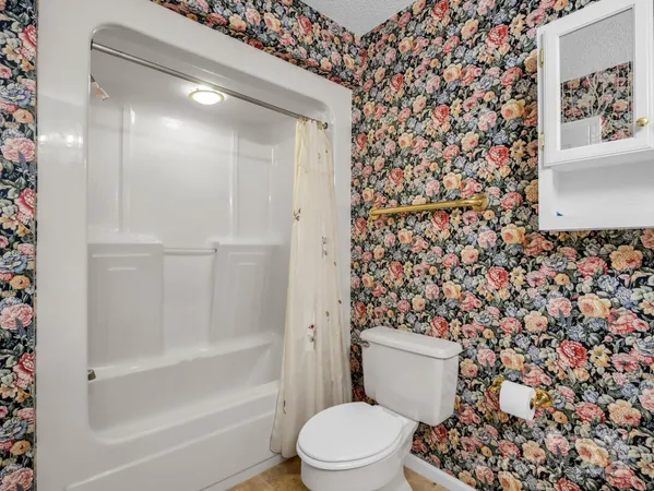 a bathroom with a toilet and a shower