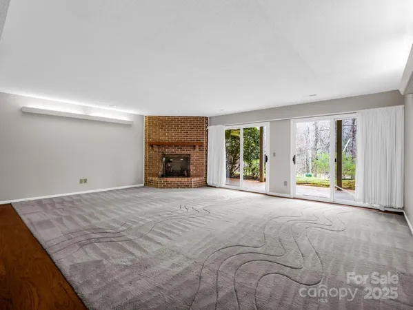 a view of empty room with wooden floor and fireplace