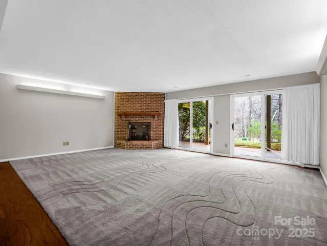 a view of empty room with wooden floor and fireplace