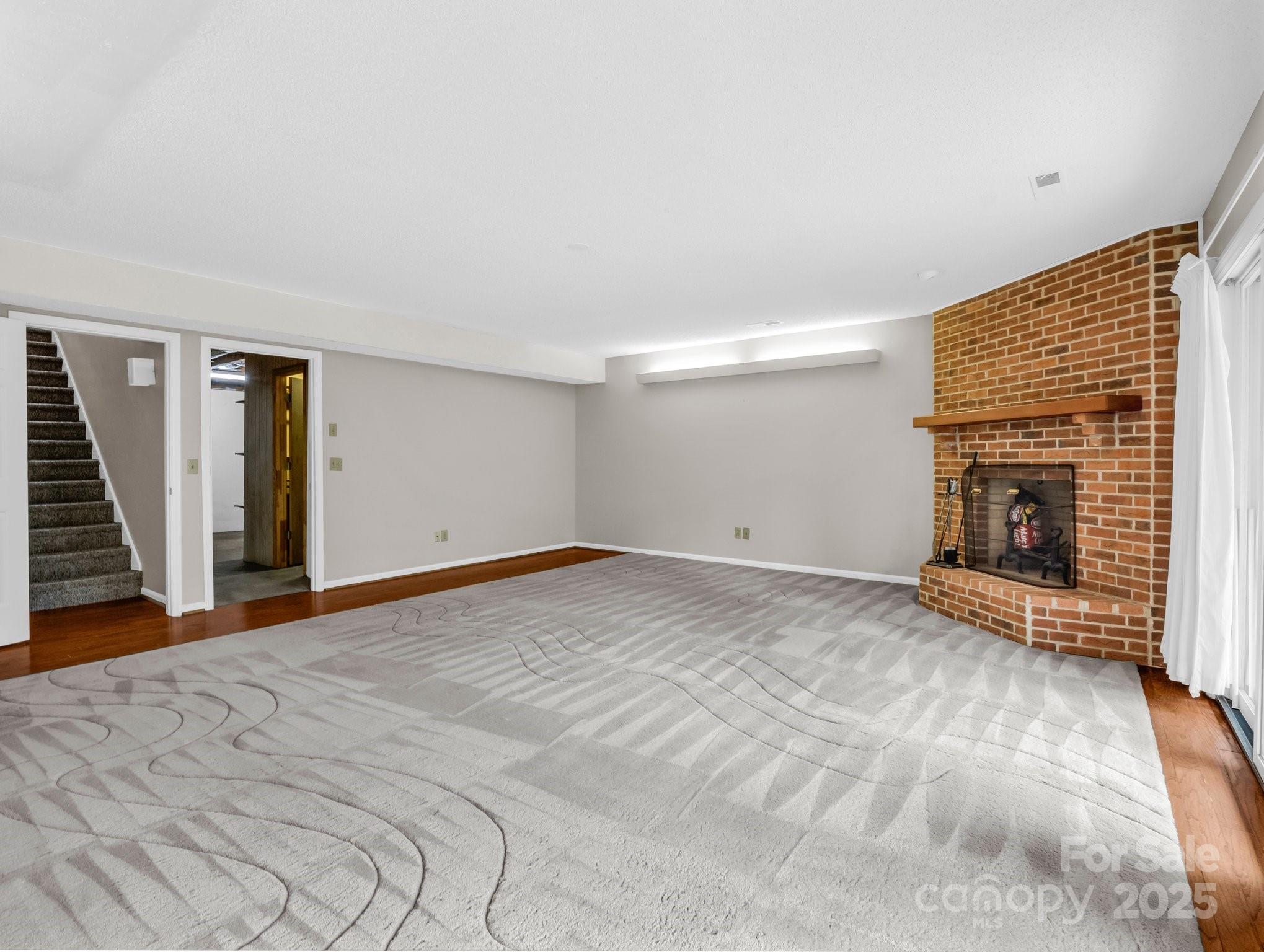 31 Hunting Country Trail Tryon, NC 28782 - Photo 29 of 40 a view of empty room with wooden floor and fireplace