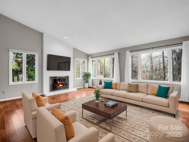 a living room with furniture a fireplace and a large window