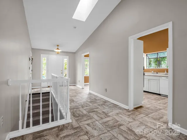a view of a hallway with wooden floor and a kitchen