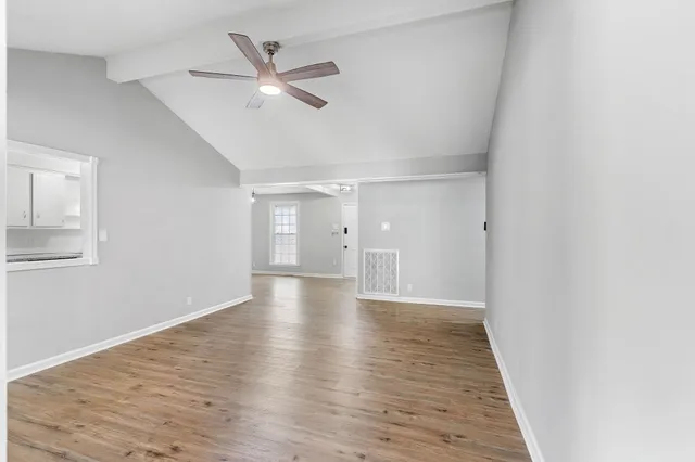 a view of an empty room with wooden floor
