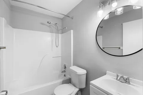 a white toilet sitting next to a bathroom sink and a shower