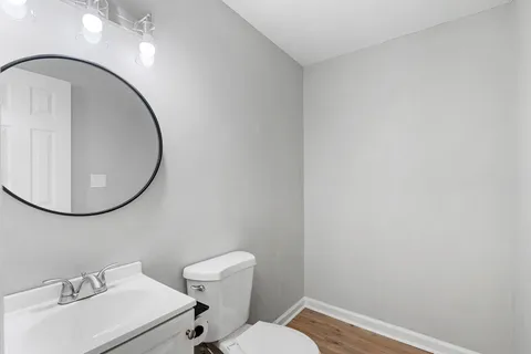 a bathroom with a sink mirror and toilet