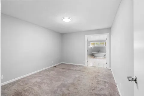 a big room with wooden floor and bathroom view