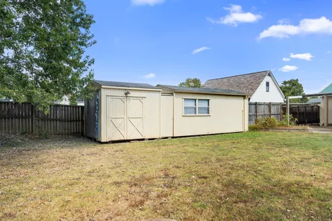 a view of a house with backyard and a tree