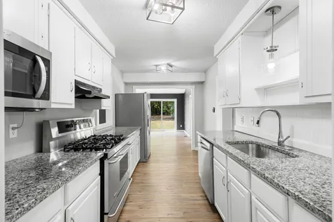 a kitchen with granite countertop stainless steel appliances and cabinets
