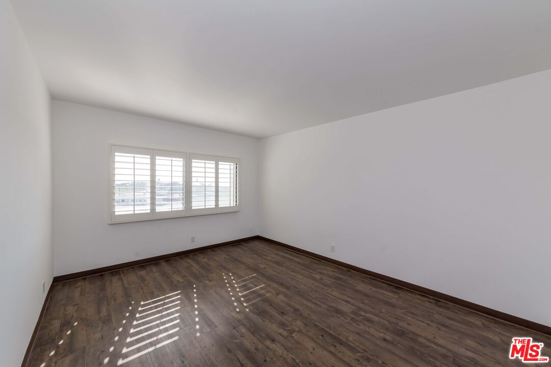 8180 Manitoba Street, Unit 248 Playa del Rey, CA 90293 - Photo 12 of 40 a view of an empty room with wooden floor and a window