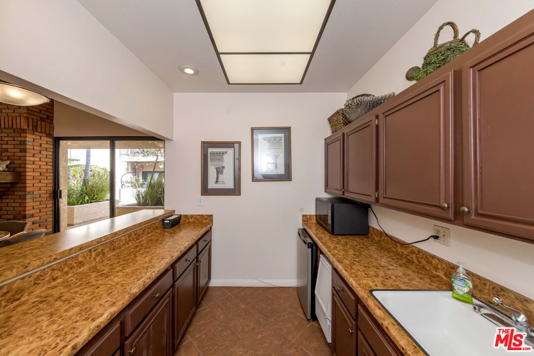 8180 Manitoba Street, Unit 248 Playa del Rey, CA 90293 - Photo 34 of 40 a kitchen with granite countertop a sink and a stove top oven