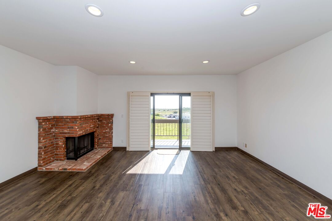8180 Manitoba Street, Unit 248 Playa del Rey, CA 90293 - Photo 5 of 40 an empty room with wooden floor fireplace and windows