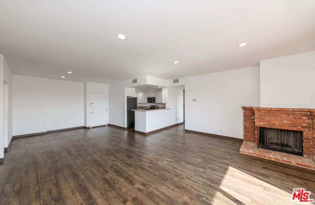 8180 Manitoba Street, Unit 248 Playa del Rey, CA 90293 - Photo 6 of 40 a view of an empty room with wooden floor fireplace and a window
