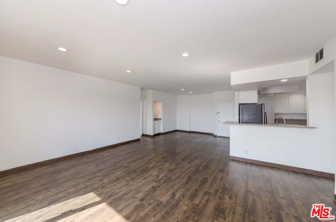 8180 Manitoba Street, Unit 248 Playa del Rey, CA 90293 - Photo 7 of 40 an empty room with wooden floor and kitchen view