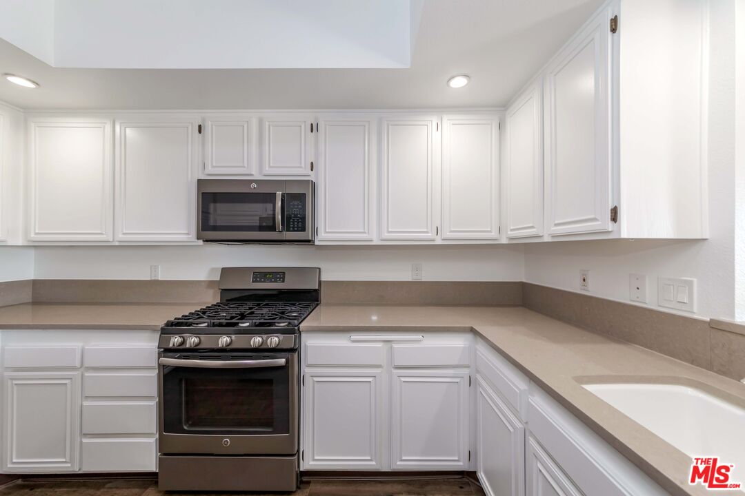 8180 Manitoba Street, Unit 248 Playa del Rey, CA 90293 - Photo 9 of 40 a kitchen with granite countertop white cabinets and stainless steel appliances
