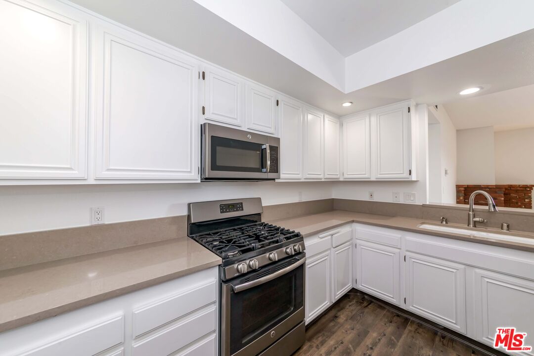 8180 Manitoba Street, Unit 248 Playa del Rey, CA 90293 - Photo 10 of 40 a kitchen with granite countertop white cabinets and stainless steel appliances