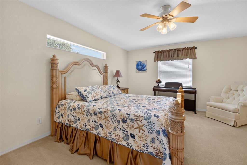 6032 Southwest 103rd Loop Ocala, FL 34476 - Photo 10 of 28 a bedroom with a bed and a chandelier