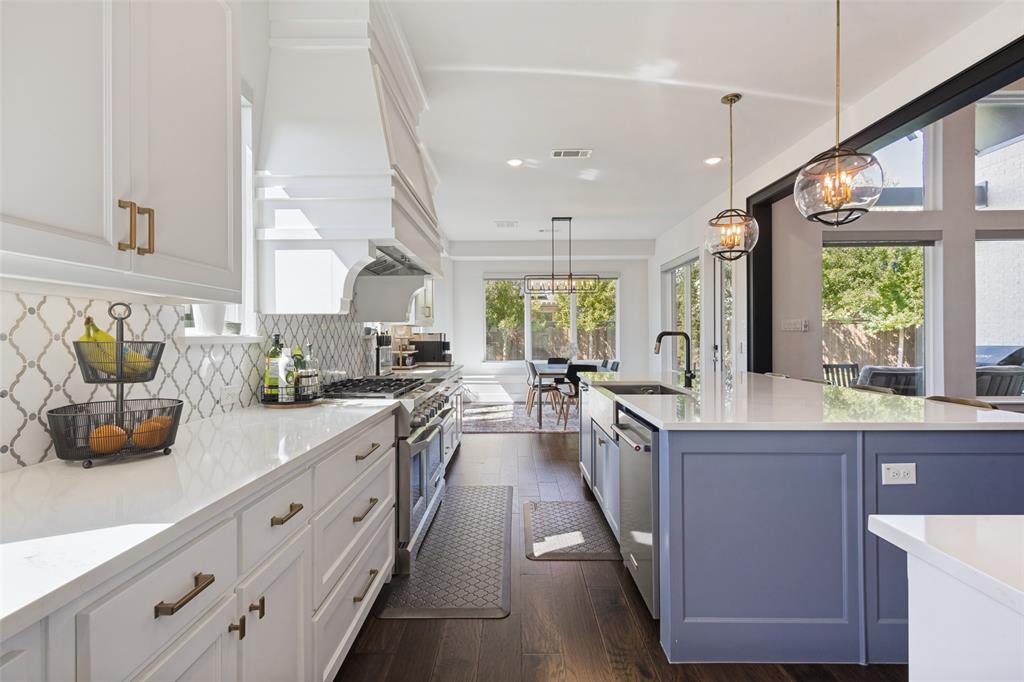 15018 Crape Myrtle Road Frisco, TX 75035 - Photo 11 of 40 Gourmet kitchen with white perimeter cabinetry, a large range, a custom range hood, a contrasting blue island, and wood-finish flooring