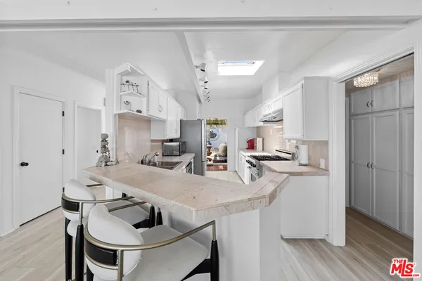 a kitchen with kitchen island a stove a table and chairs in it