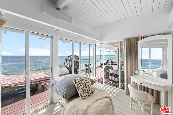 a bedroom with a bed and a large window with balcony view