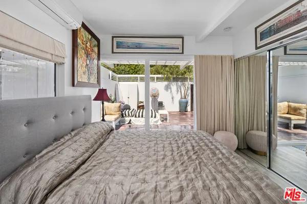 a large bed sitting in a bedroom next to a window