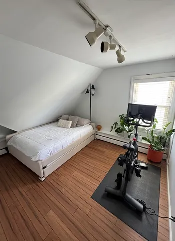 a bedroom with a bed and wooden floor