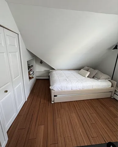 a bedroom with a bed and wooden floor