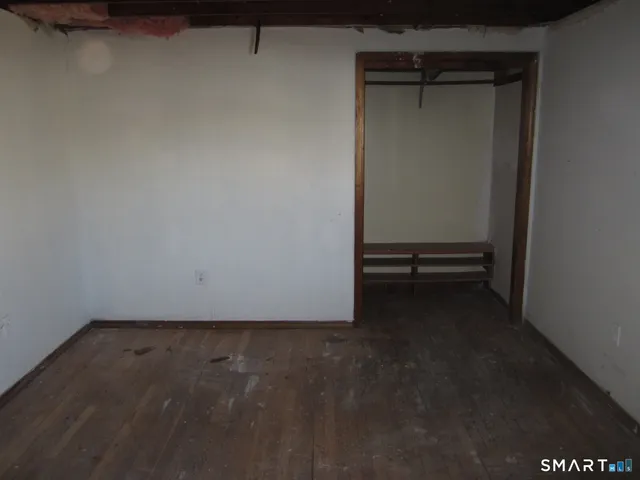 a view of a room with wooden floor and a small space