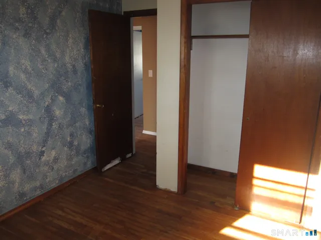 a view of empty room with wooden floor