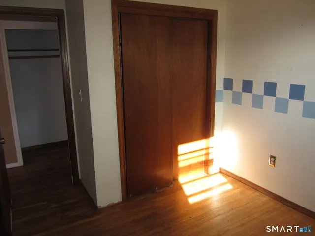 a view of entryway and hall with wooden floor