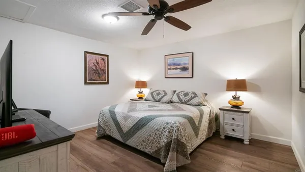 a bedroom with a bed and a painting on the wall