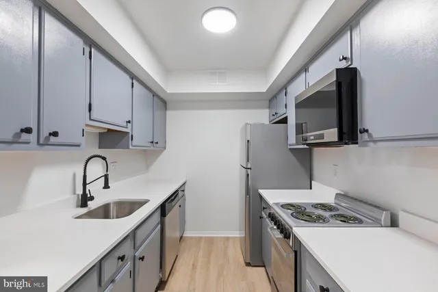 a kitchen with stainless steel appliances a sink stove and refrigerator