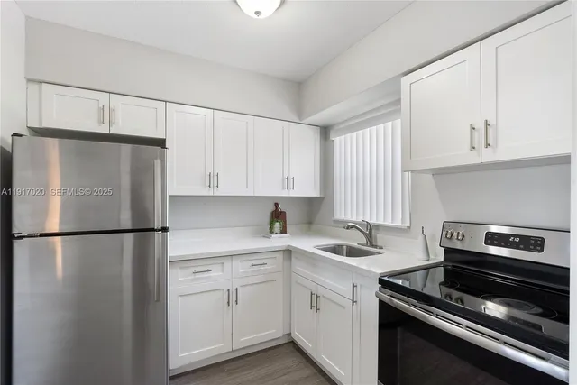 a kitchen with a refrigerator sink and cabinets