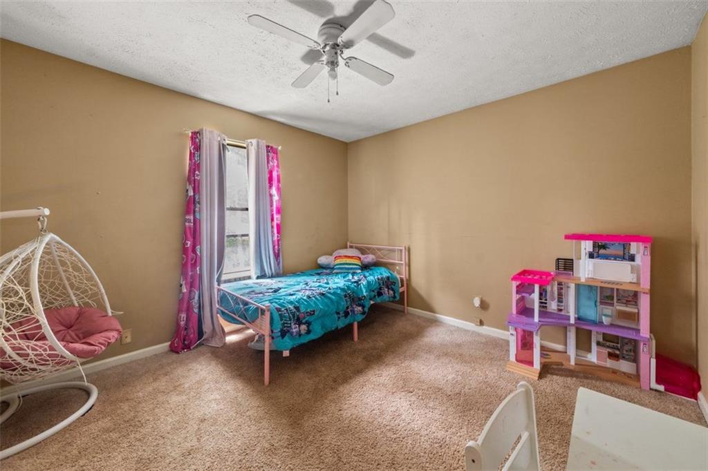 5016 Comanche Court Northwest Lilburn, GA 30047 - Photo 7 of 13 a bedroom with furniture and a chandelier