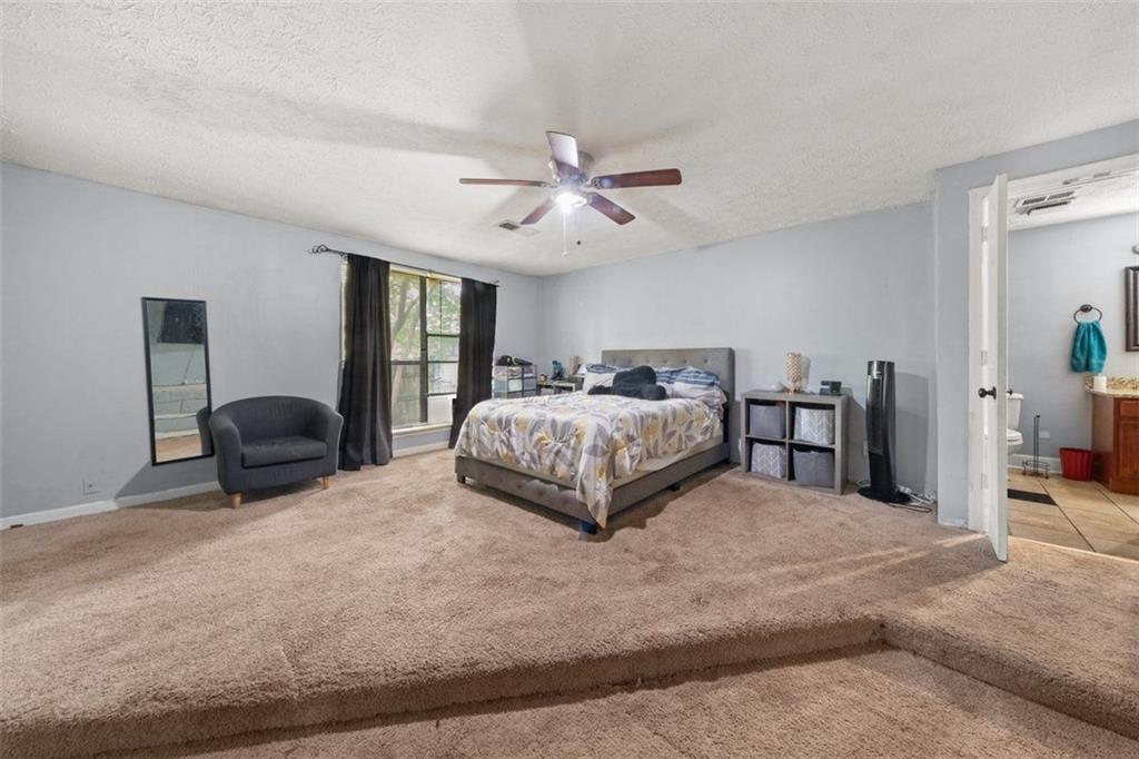 5016 Comanche Court Northwest Lilburn, GA 30047 - Photo 8 of 13 a spacious bedroom with a bed and window