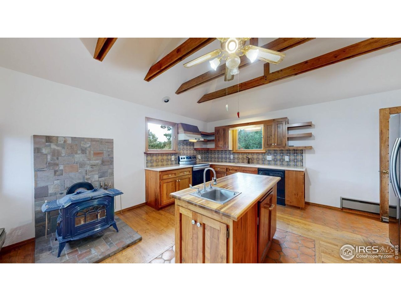 253 Apache Road Lyons, CO 80540 - Photo 6 of 32 Kitchen with Island & Wood Stove