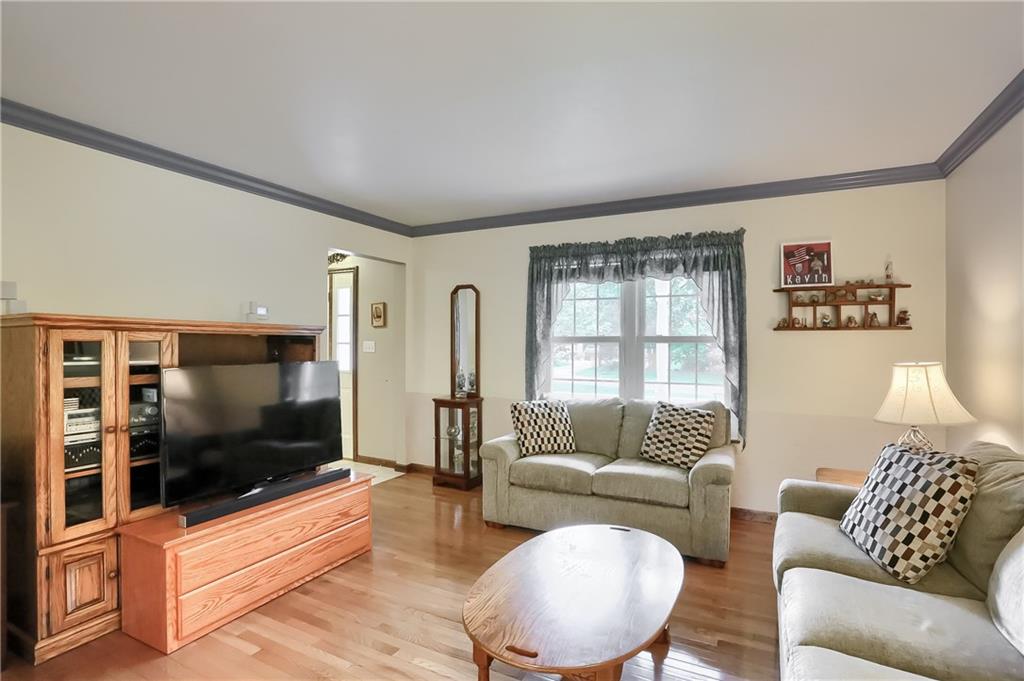 The living room is on the left of the foyer and features hardwood floors, crown molding and large sun filled windows. 